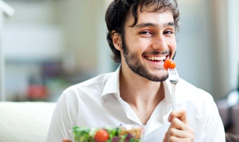 Happy man eating a salad