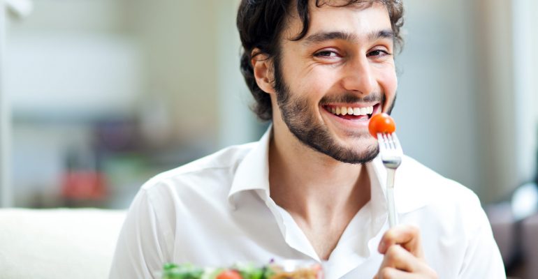 Happy man eating a salad