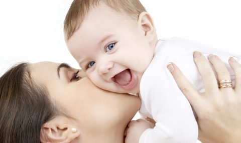 laughing baby playing with mother